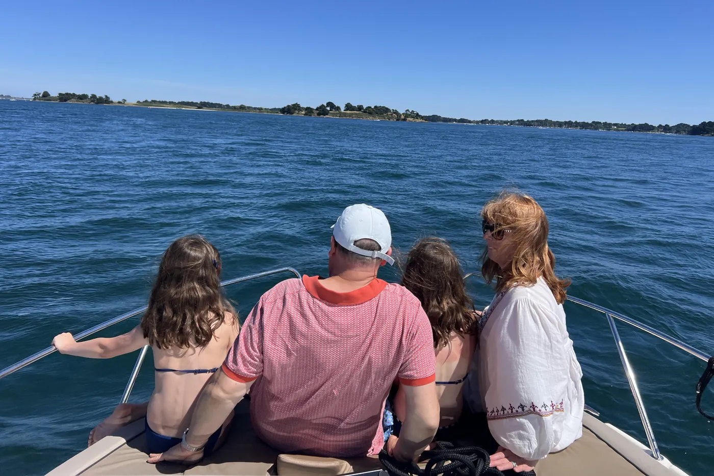 Une famille à l'avant du bateau, face aux îles